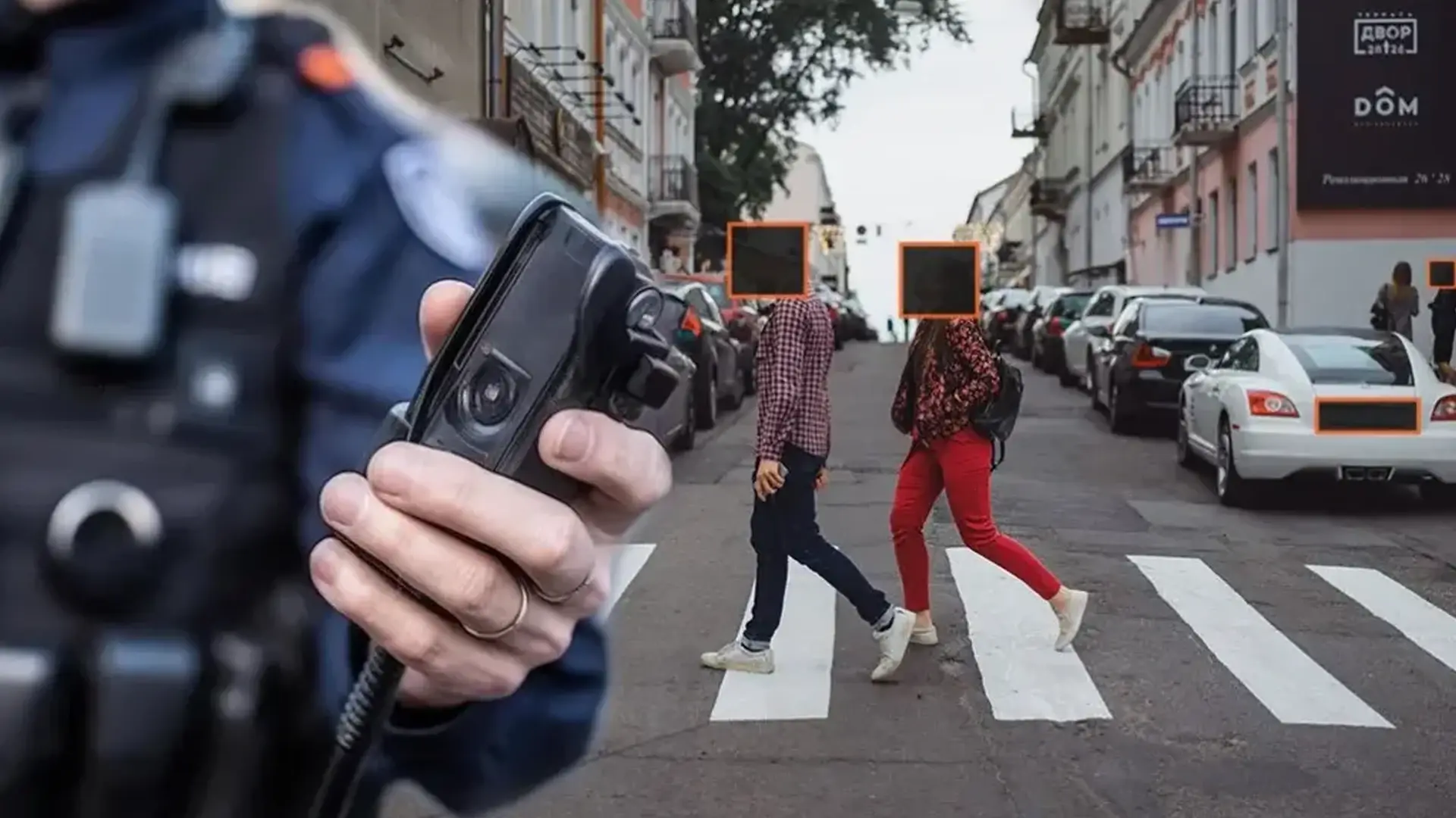 A law enforcement officer holding a body worn camera.