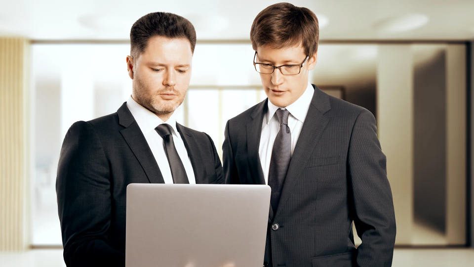 Two officials looking at a laptop