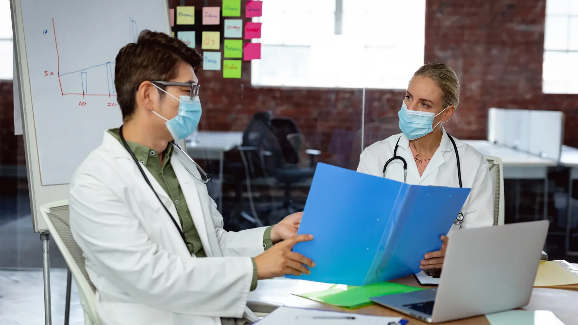 Medical researcher team discussing about medical records that needs to be redacted