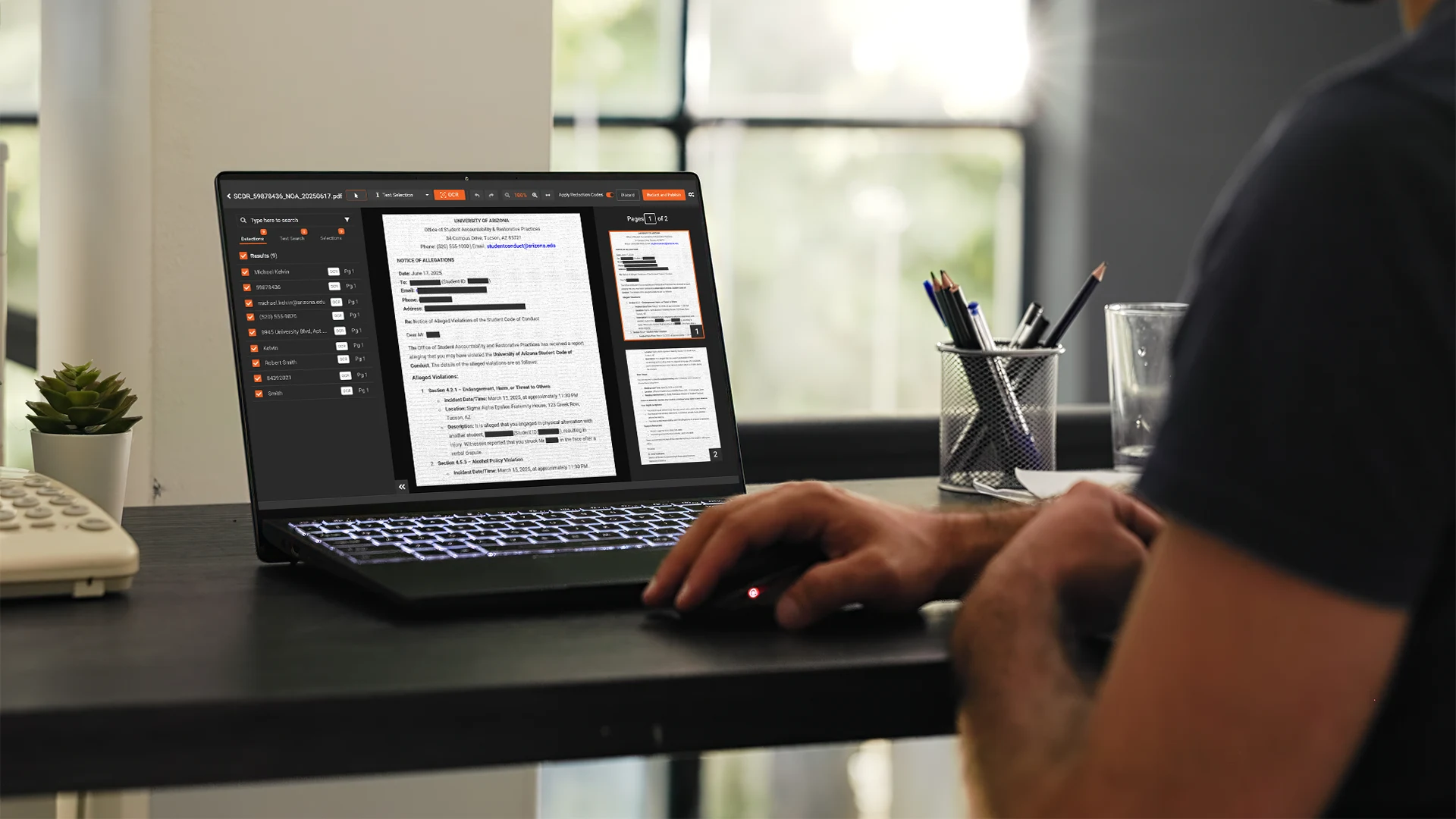 Person reviewing digital documents on a laptop at a desk.
