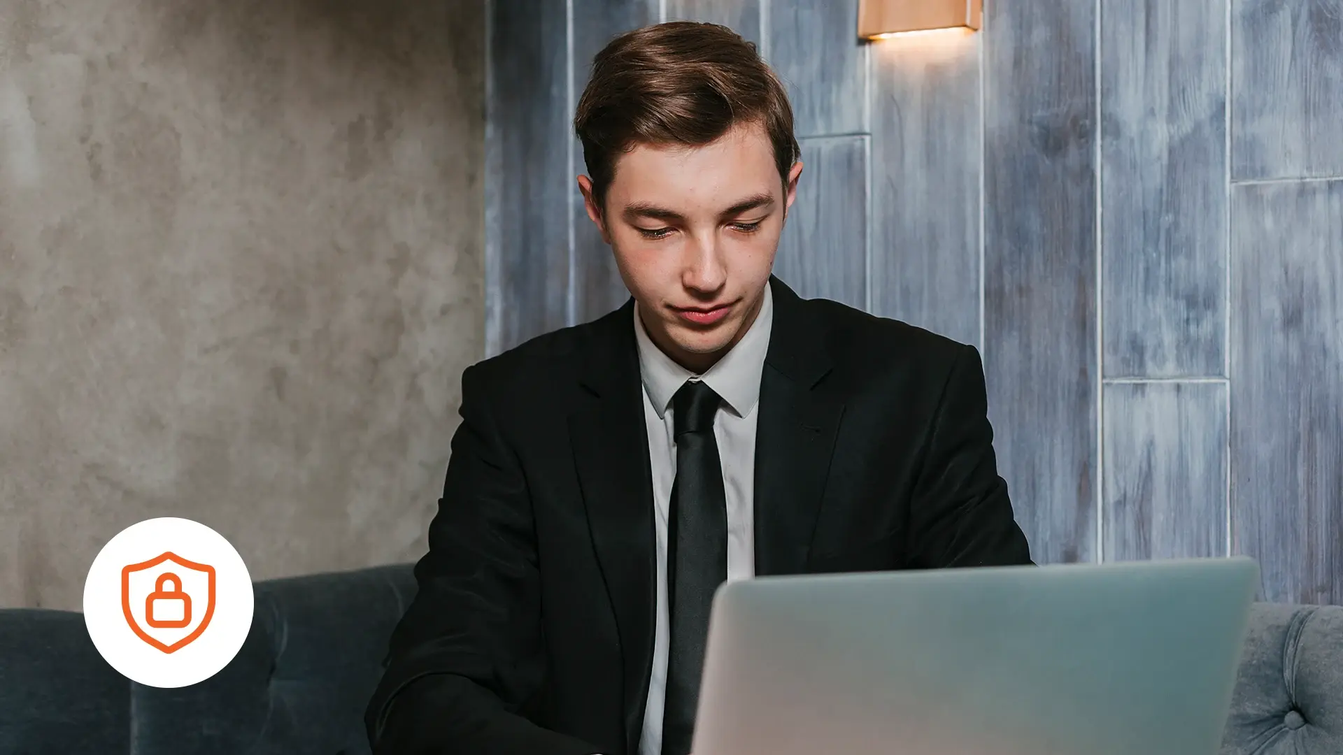 A professional using a laptop and a security icon shown at the bottom left