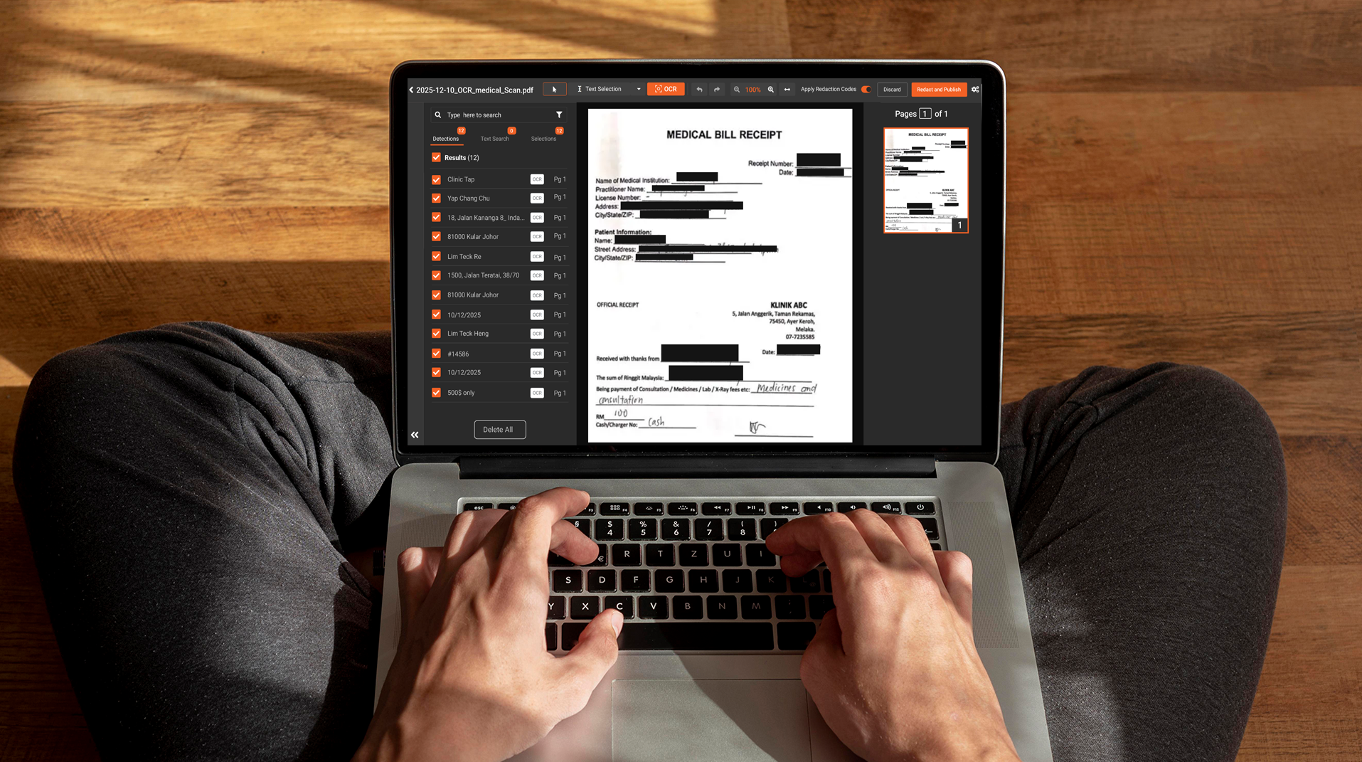 Person using a laptop to review and redact a medical bill document.
