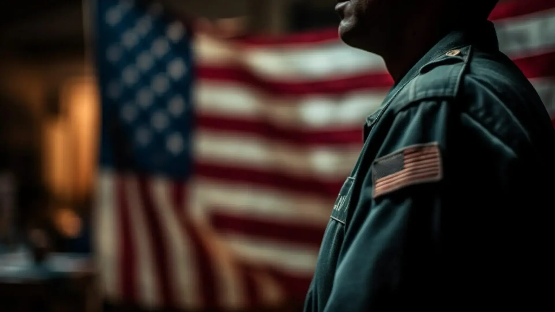 US soldier with face slightly hidden and a blurred background of the U.S flag.